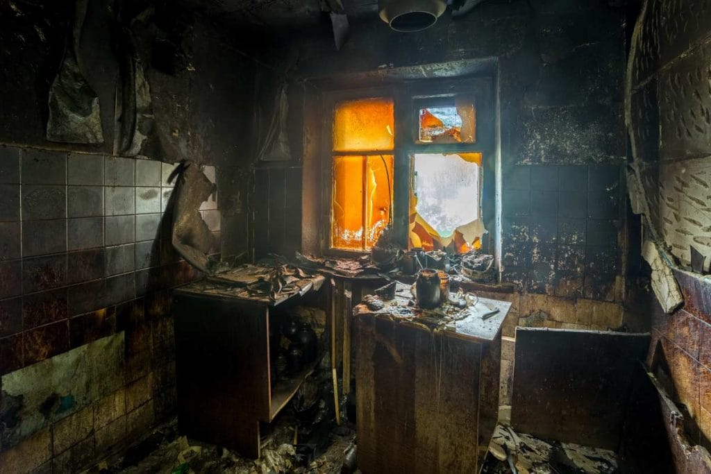 Kitchen interior charred and coated in soot after a house fire